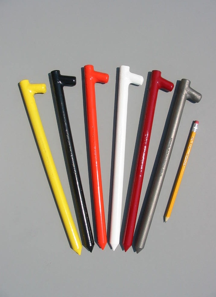 Twelve inch forged head tent stakes shown in six color options with a pencil for scale